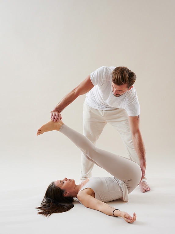 Thai Yoga Praktiker begleitet achtsam in Yogaposition – Ausbildung in Körperarbeit